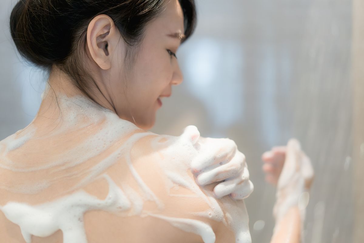 Asian woman using body wash in the shower