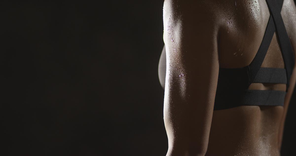 Torso of a woman sweating in a sports bra