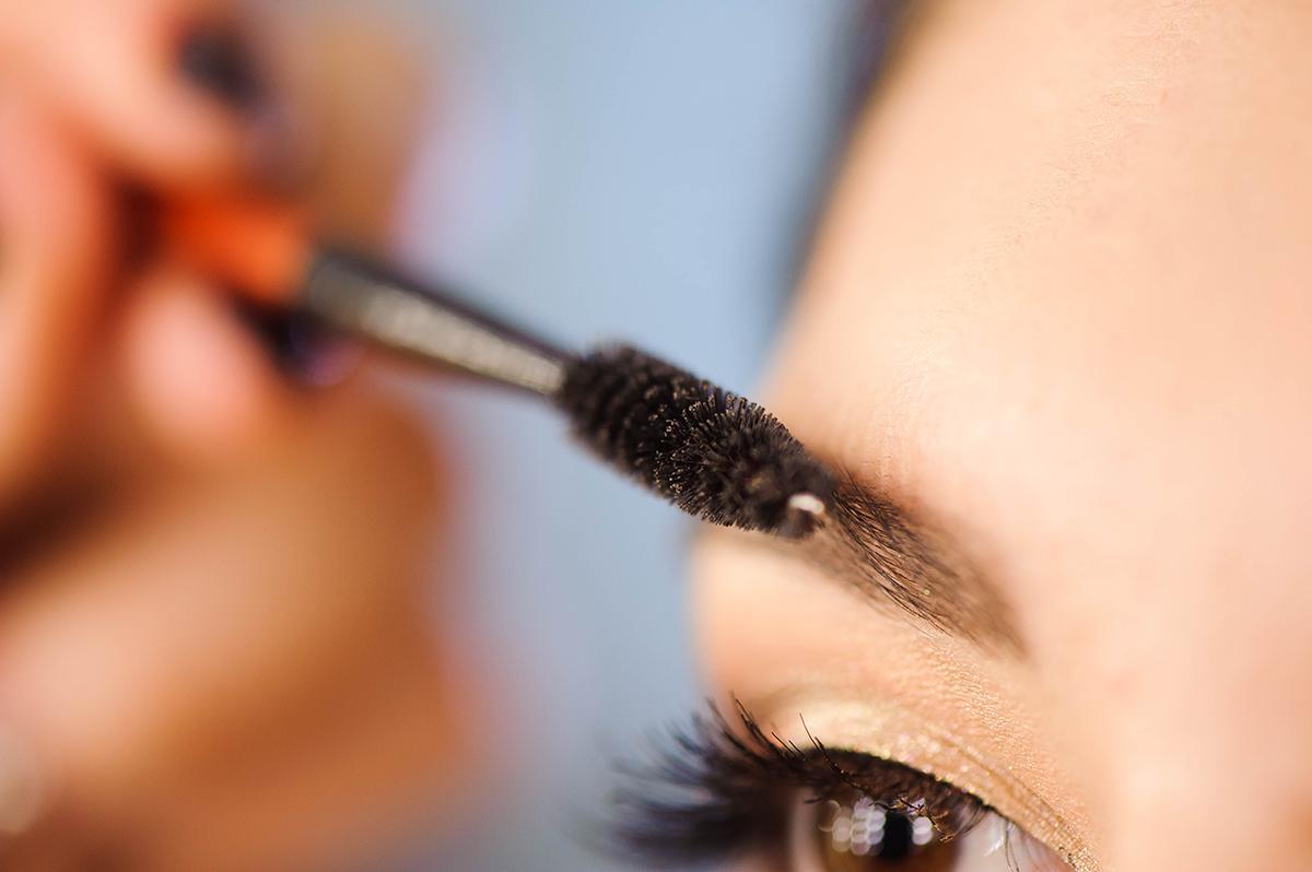 Woman grooms eyebrows with spoolie