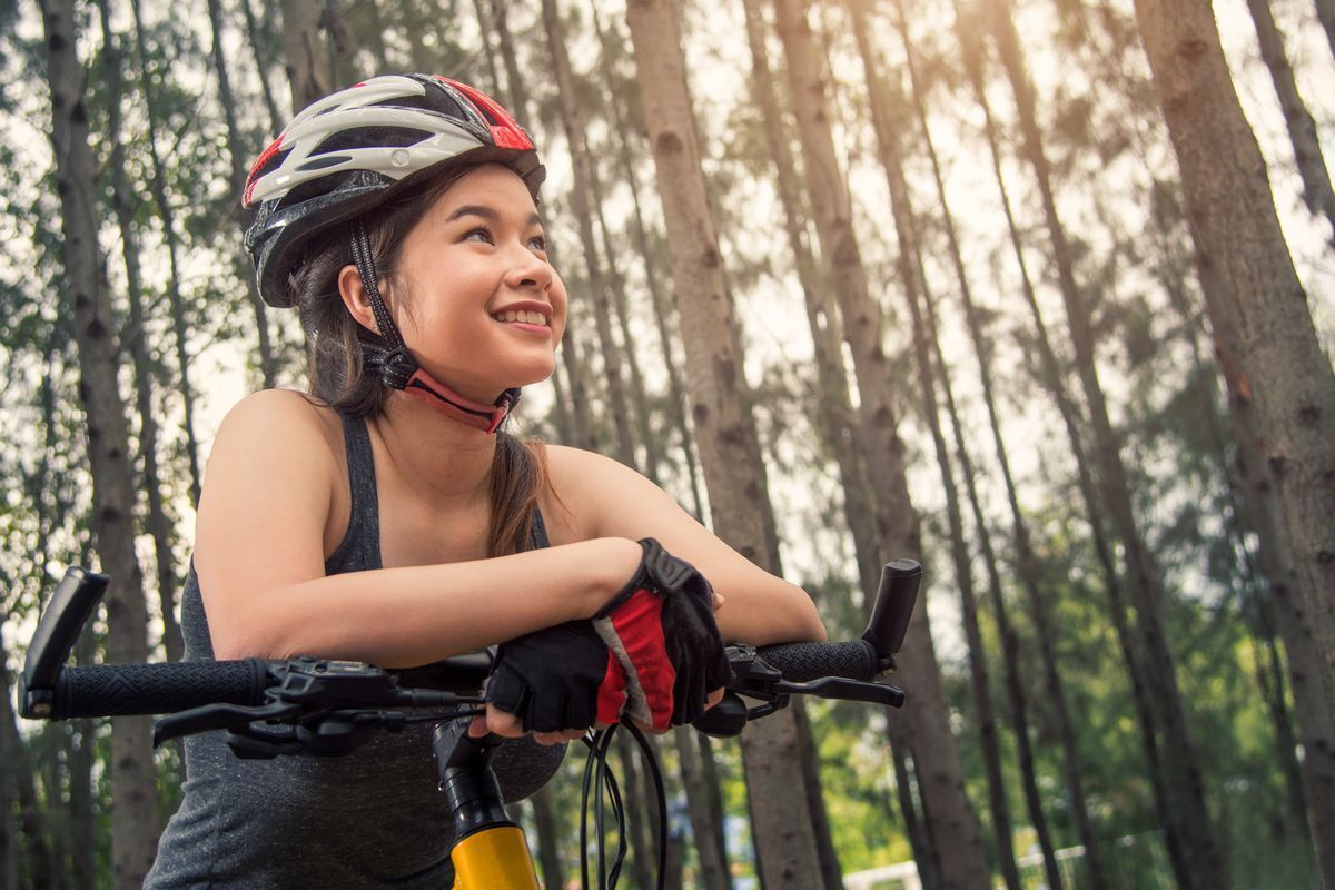 Asian girl sweating from biking in the woods