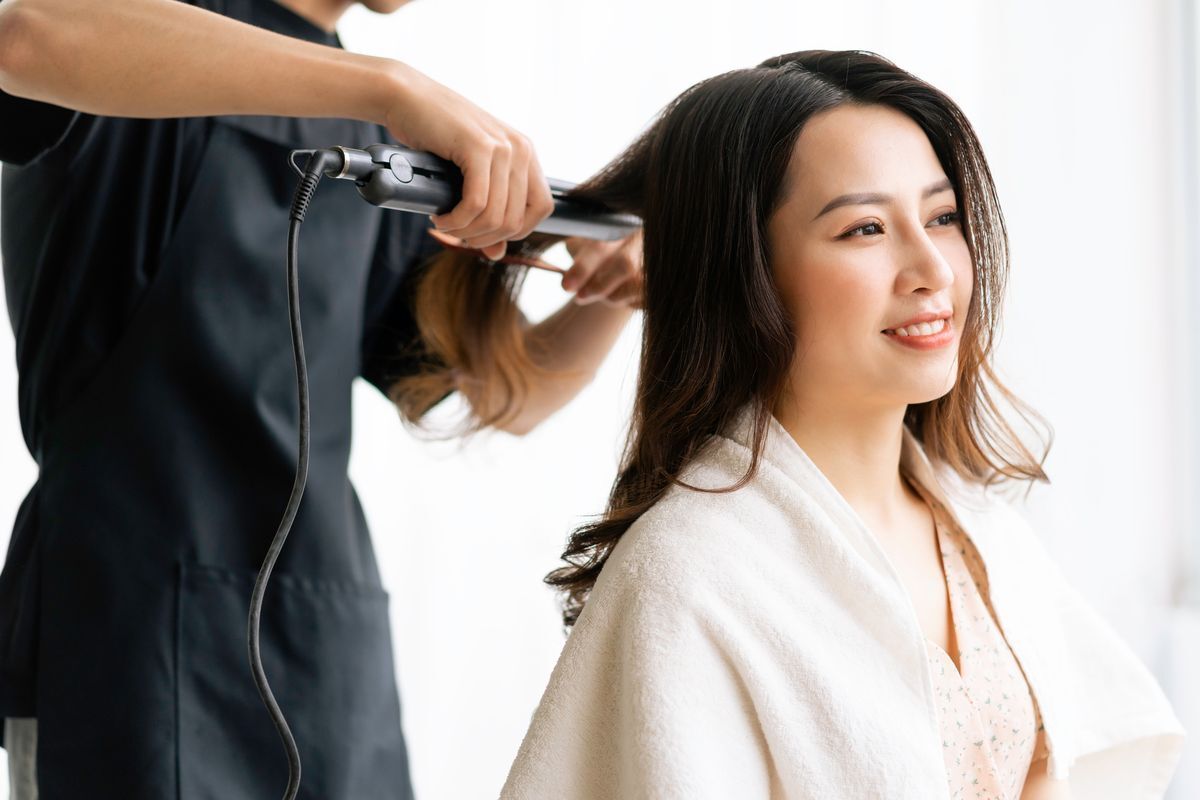 Asian woman being styled at a salon