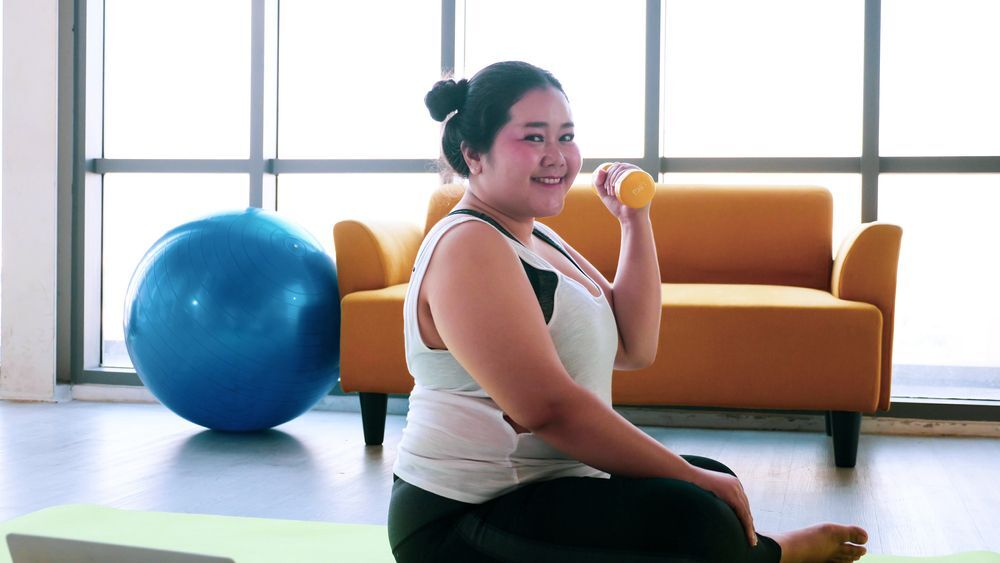 A confident woman exercising with a dumbell