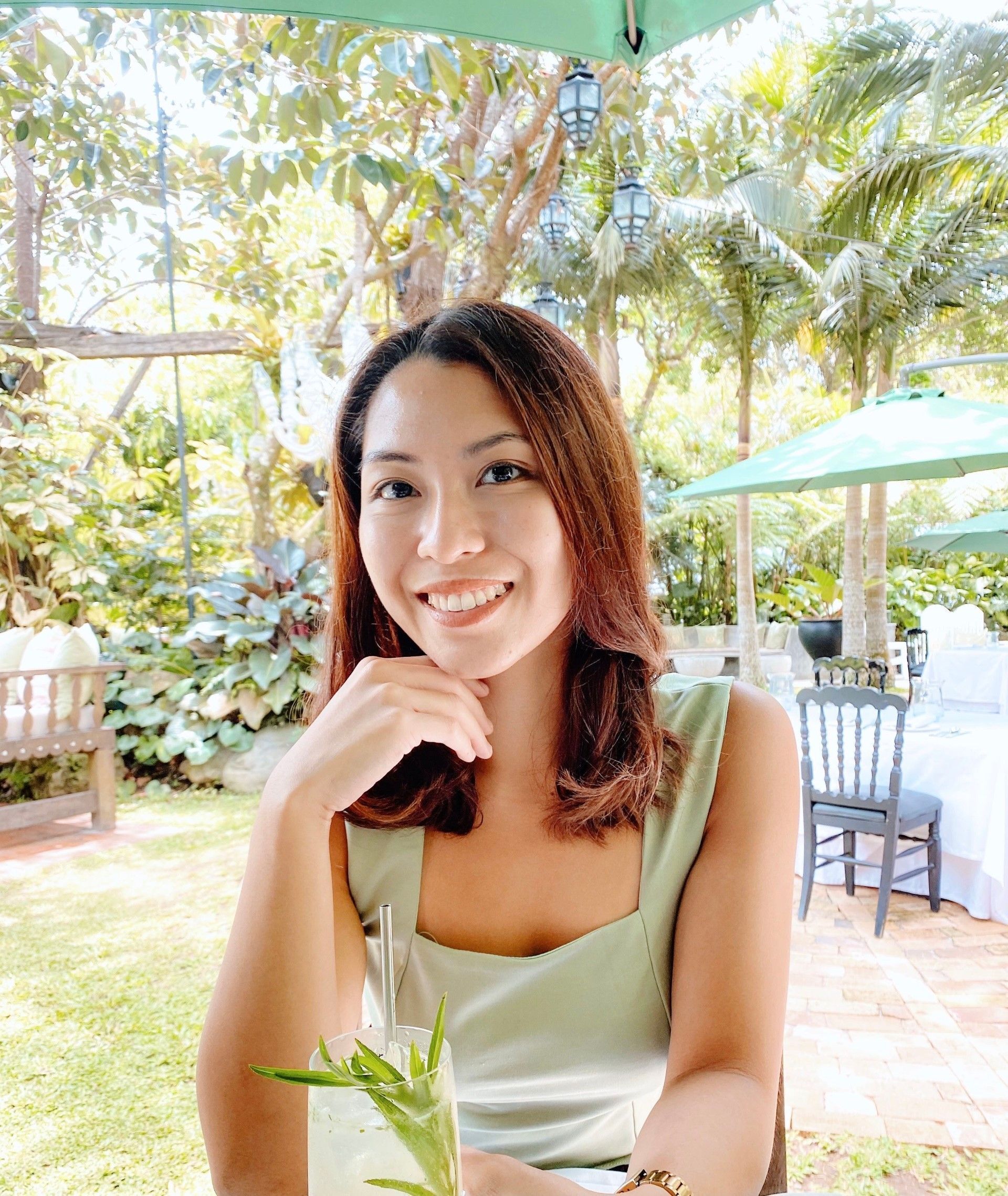 A portrait of smiling woman wearing green dress.