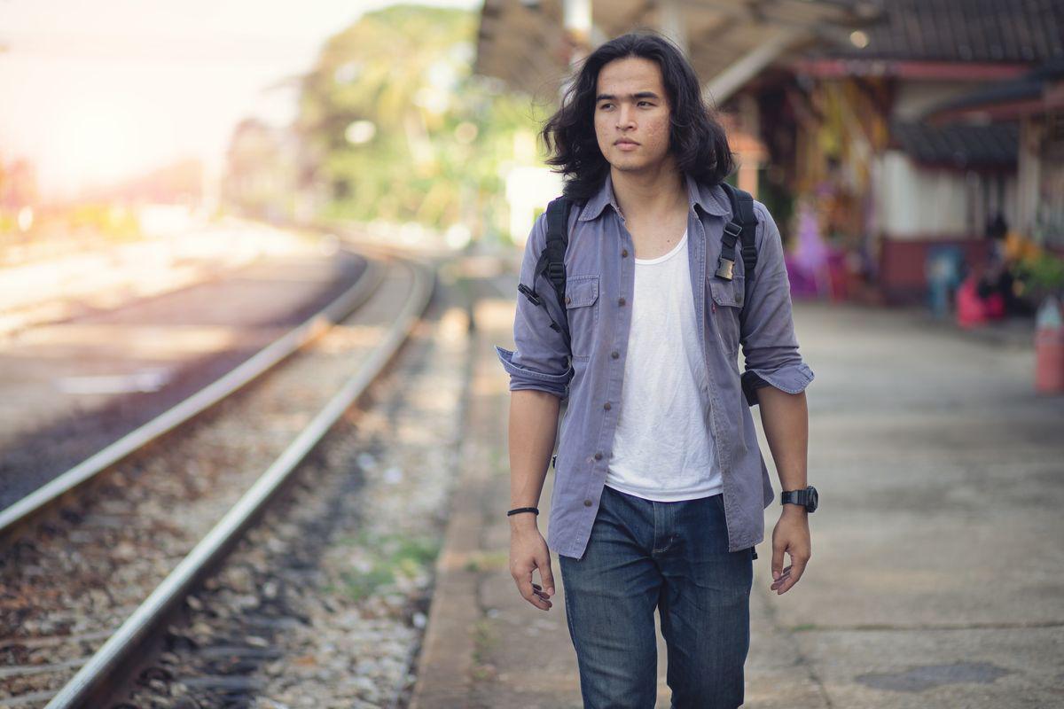 Asian man with long hair walking