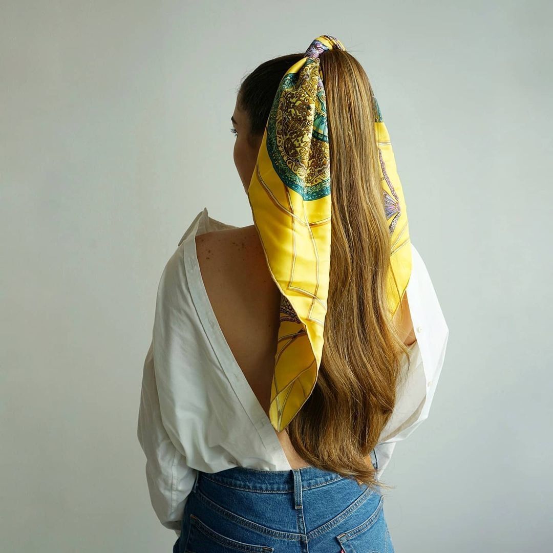 Wearing a silk scarf as a hair tie brings a vintage and classy feel to your summer OOTD. (Instagram.com/alexandrarriaga)