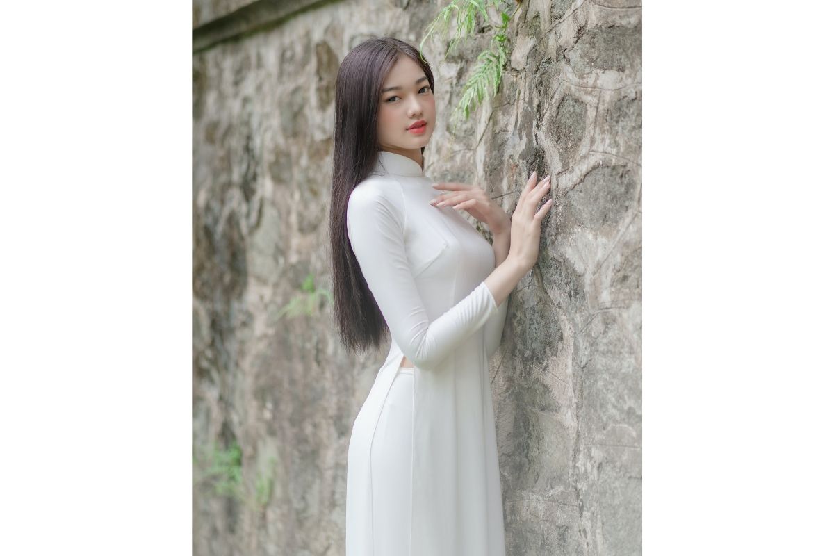 Mẫu áo dài học sinh cô gái tựa vào tường đá rêu phong