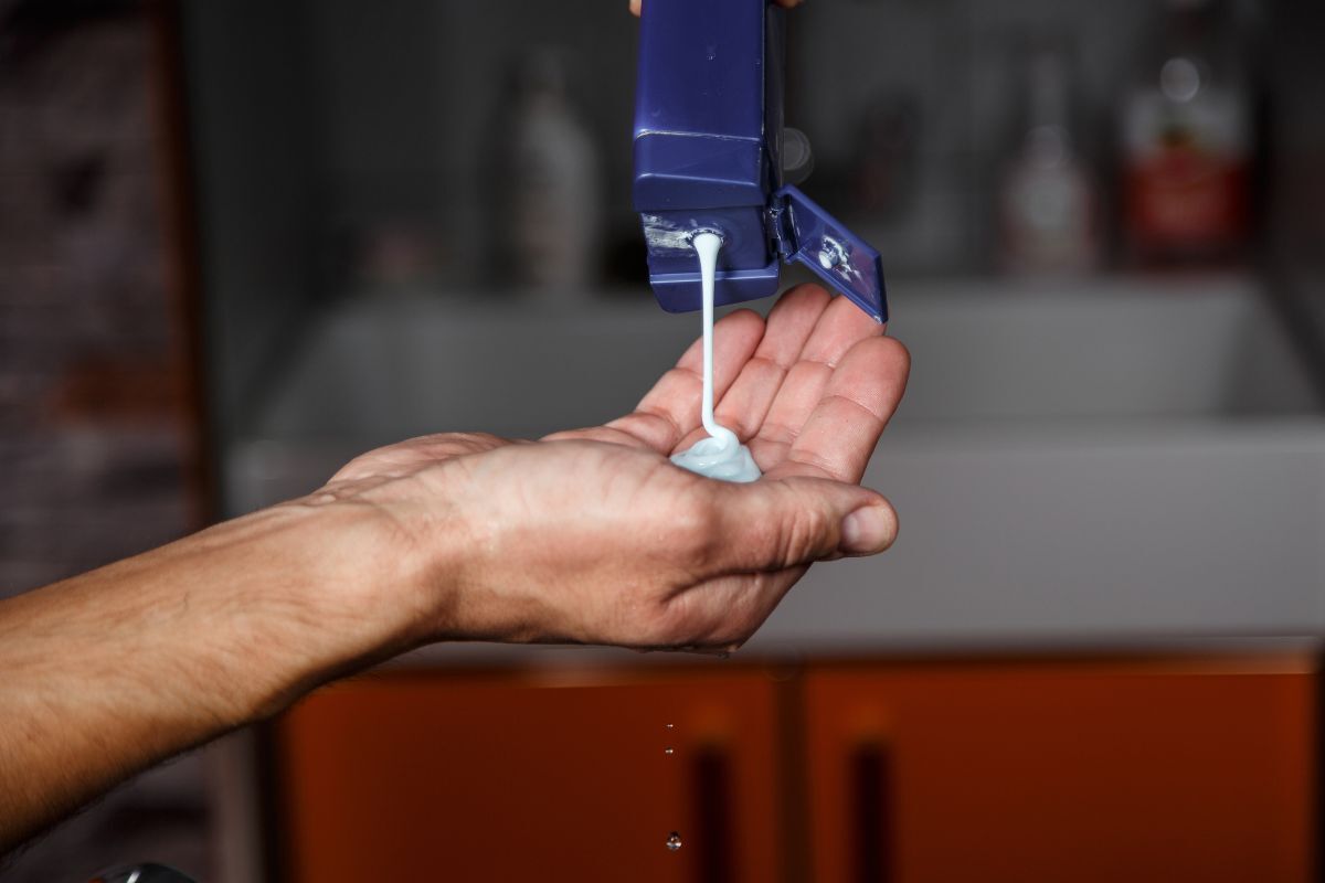 dầu gội trị gàu đổ dầu gội trị gàu ra lòng bàn tay đàn ông