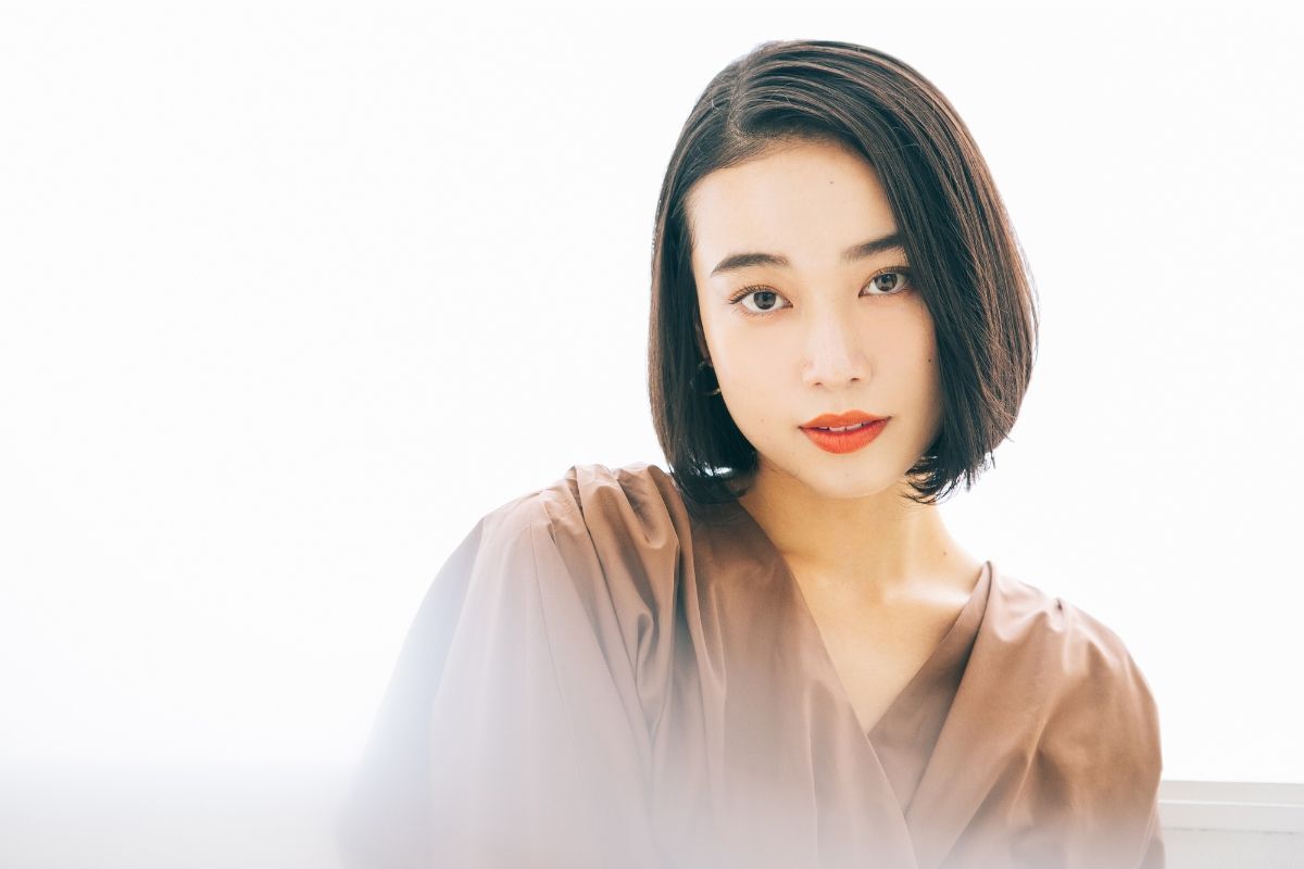 Tóc lob cho mặt vuông cô gái mặc váy nâu chụp trên nền trắng