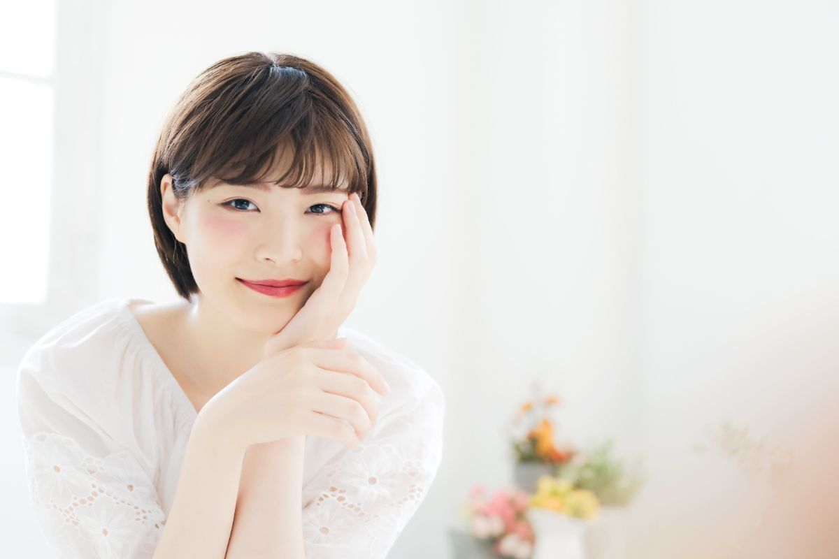 Tóc ngắn cho mặt dài trán cao cô gái mặc áo trắng để kiểu tóc tém uốn phồng