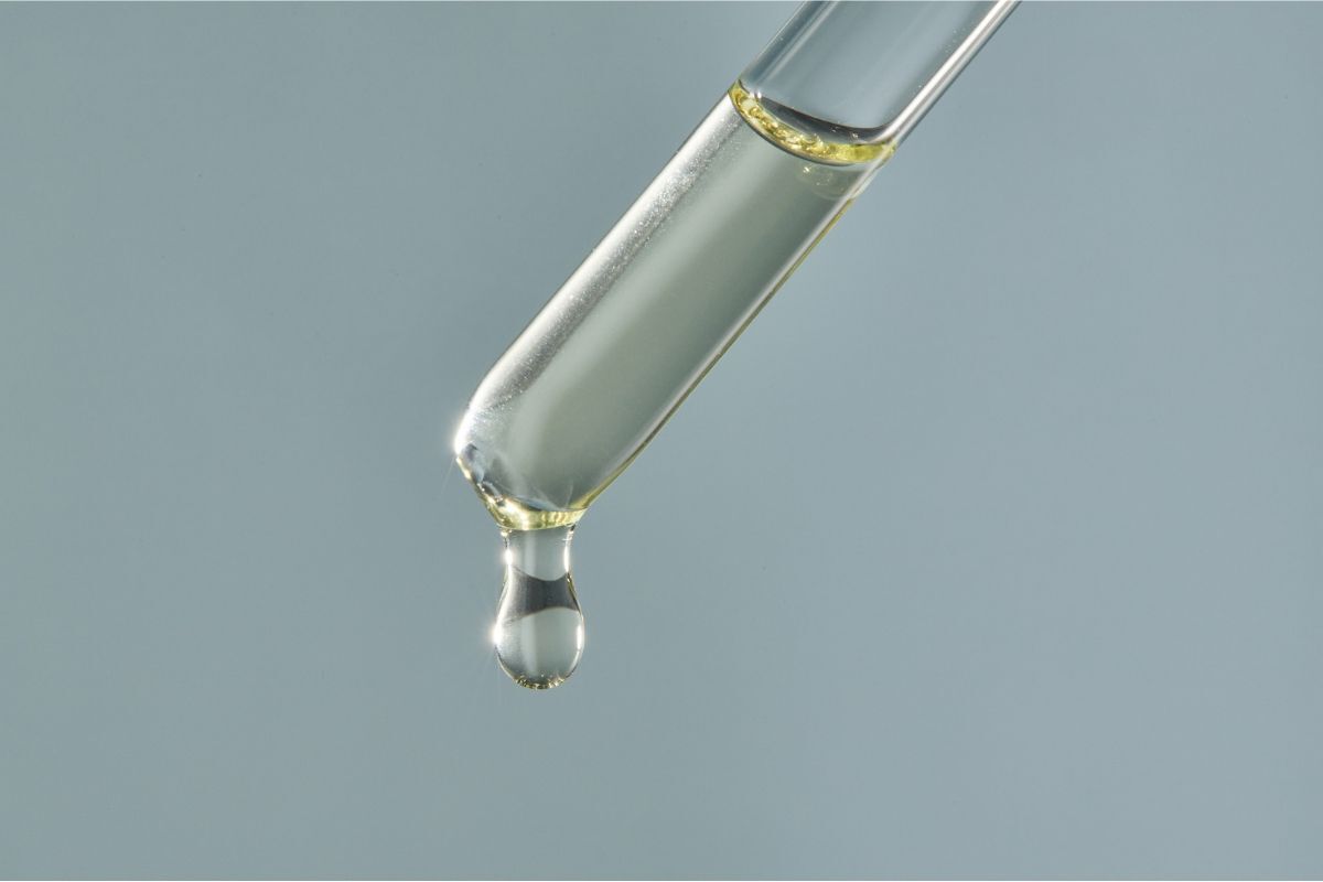 thuốc duỗi tóc ống serum chứa tinh chất dầu màu vàng chụp cận trên nền xám