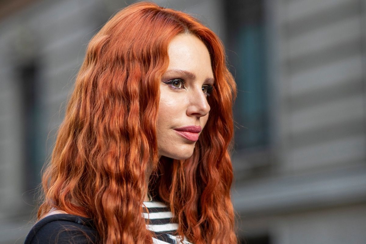 Tóc màu đỏ cam cô gái mặc áo kẻ ngang đen trắng với mái tóc xoăn sóng