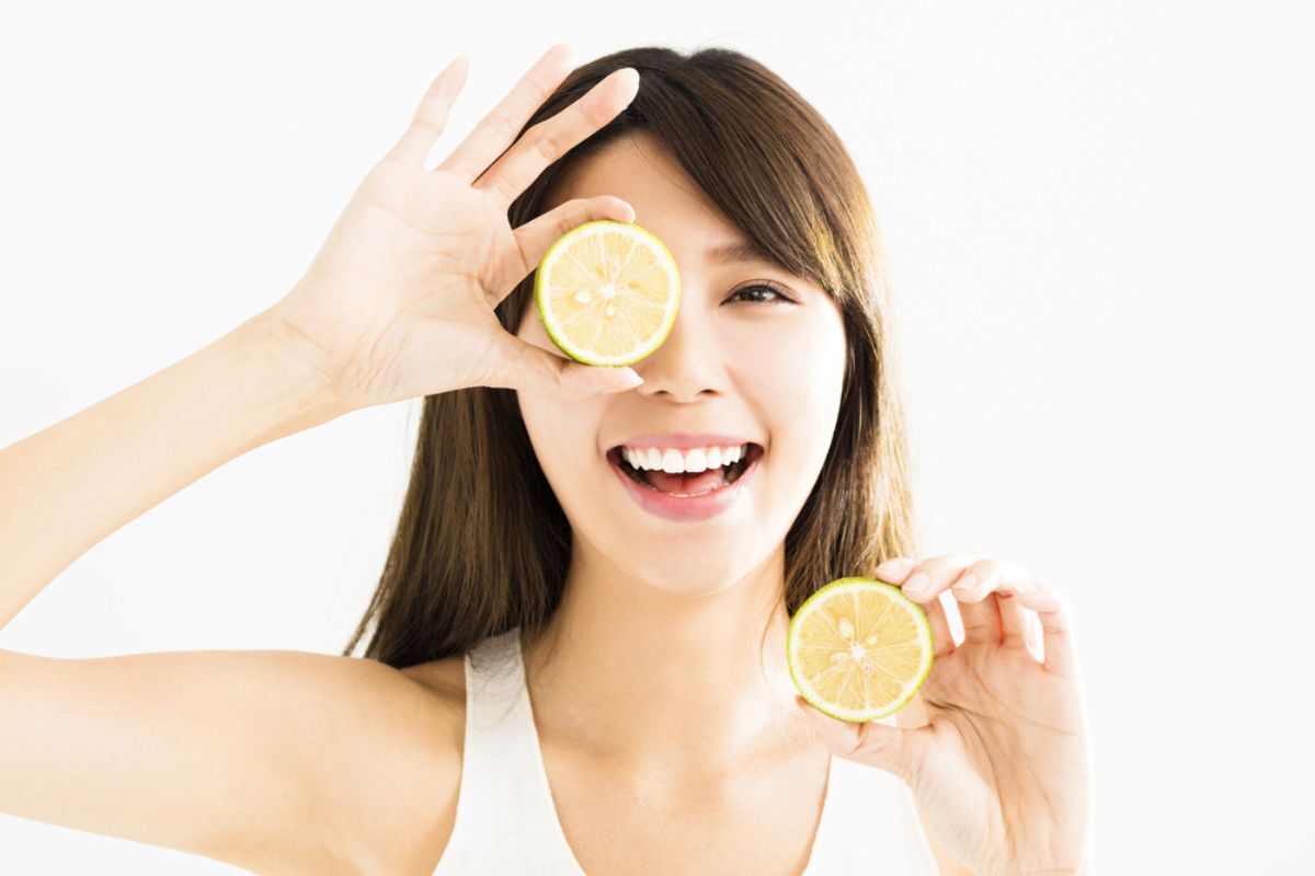 trị nấm da đầu tại nhà bằng chanh tại sao chanh có thể trị nấm da đầu cô gái cười tươi xoã tóc và dùng lát chanh che mắt