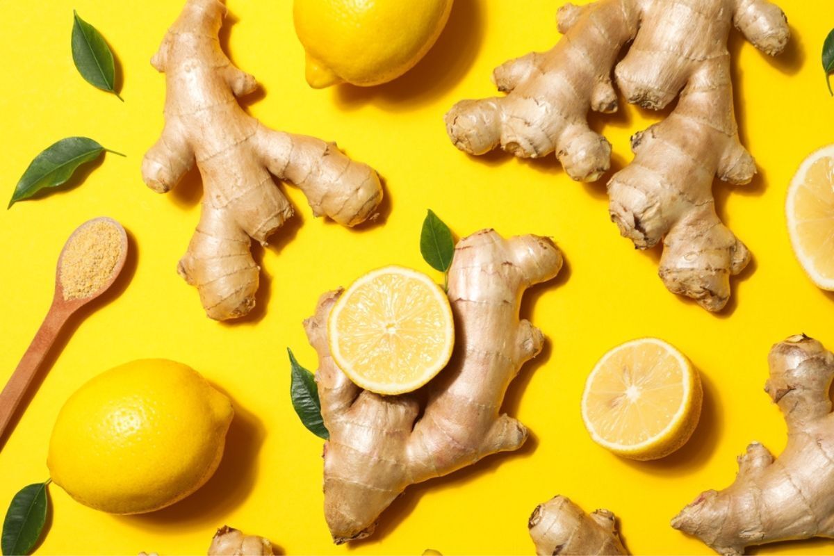 trị nấm da đầu tại nhà bằng chanh Cách trị nấm da đầu bằng chanh, gừng và tinh dầu tràm trà gừng và chanh đặt trên nền vàng