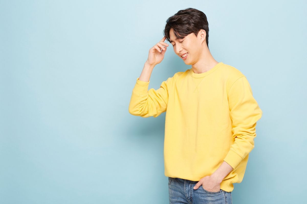 Thương hiệu sweater local brand chàng trai mặc áo màu vàng chụp trên nền xanh dương