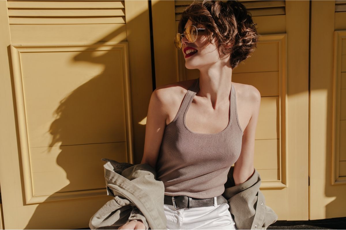 những màu tóc nhuộm lâu phai cô gái tóc ngắn màu nâu đen uốn đeo mắt kính mặc áo ba lỗ nâu đứng dưới bóng râm