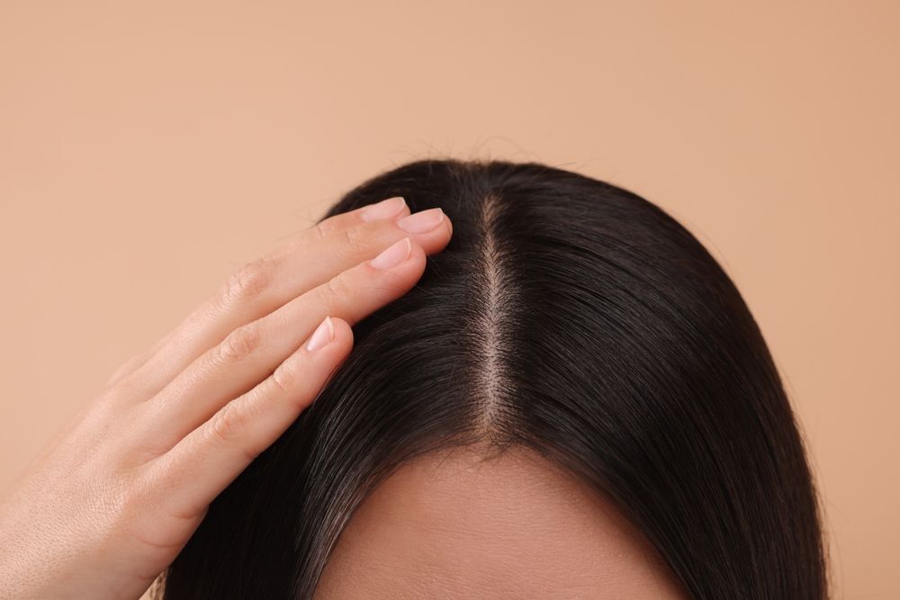 tại sao gội đầu xong vẫn có gàu cô gái chạm bàn tay trái lên đầu