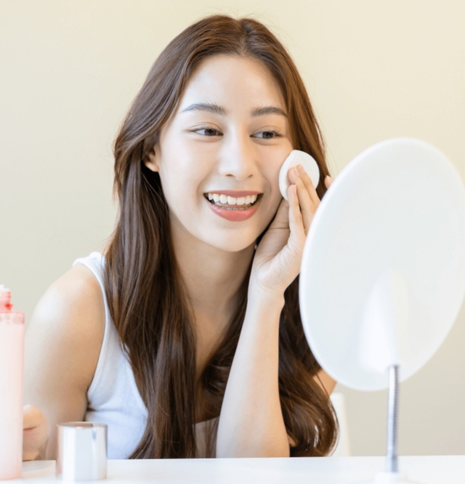 chăm sóc da Bỏ qua bước sử dụng toner cô gái cười tươi đang soi gương và thoa mỹ phẩm lên da mặt