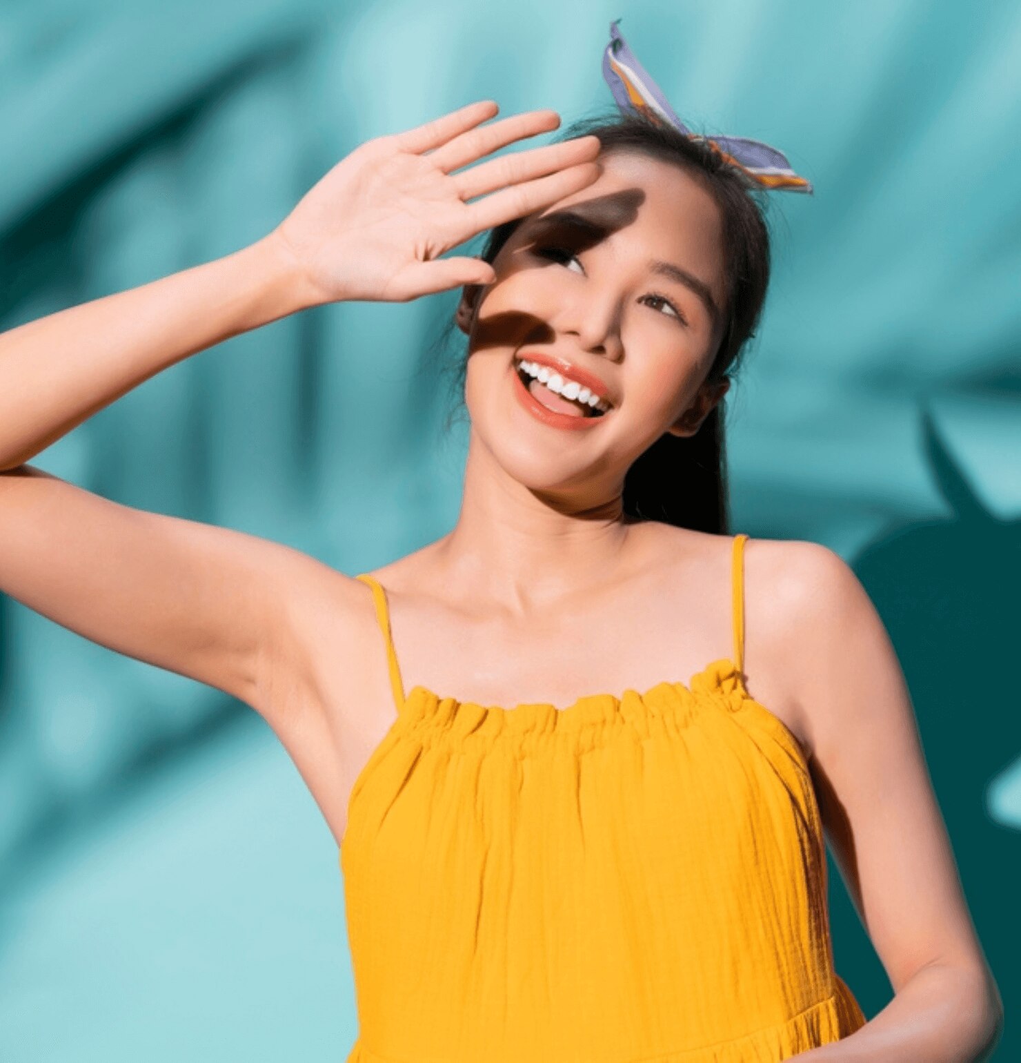 chăm sóc da chỉ bôi kem chống nắng vào những ngày nắng cô gái mặc váy màu vàng đang giơ tay lên che nắng