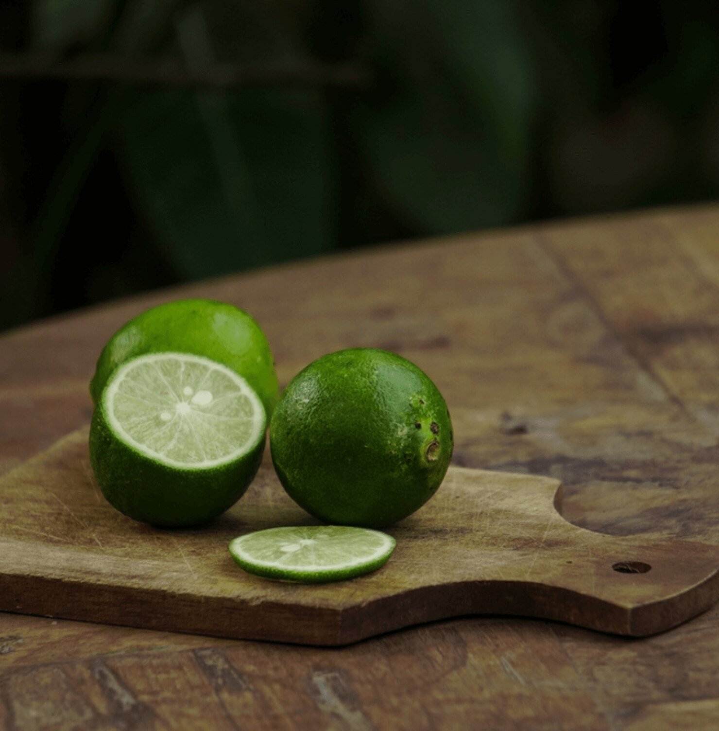 tóc bết cách để tóc không bết dùng chanh quả chanh và lát chanh màu xanh lá trên thớt gỗ