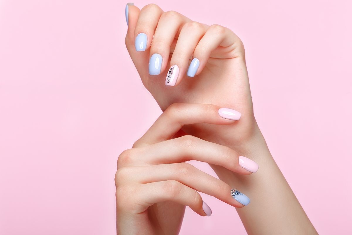 nail hàn quốc móng tay màu xanh pastel và hồng pastel có đính đá trên nền hồng