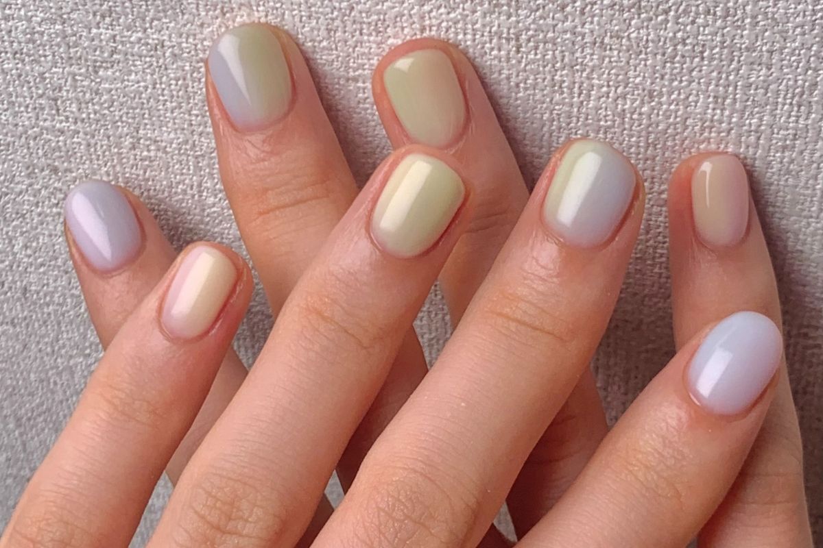 mẫu nail sơn thạch bàn tay phụ nữ đặt trên nền vải 