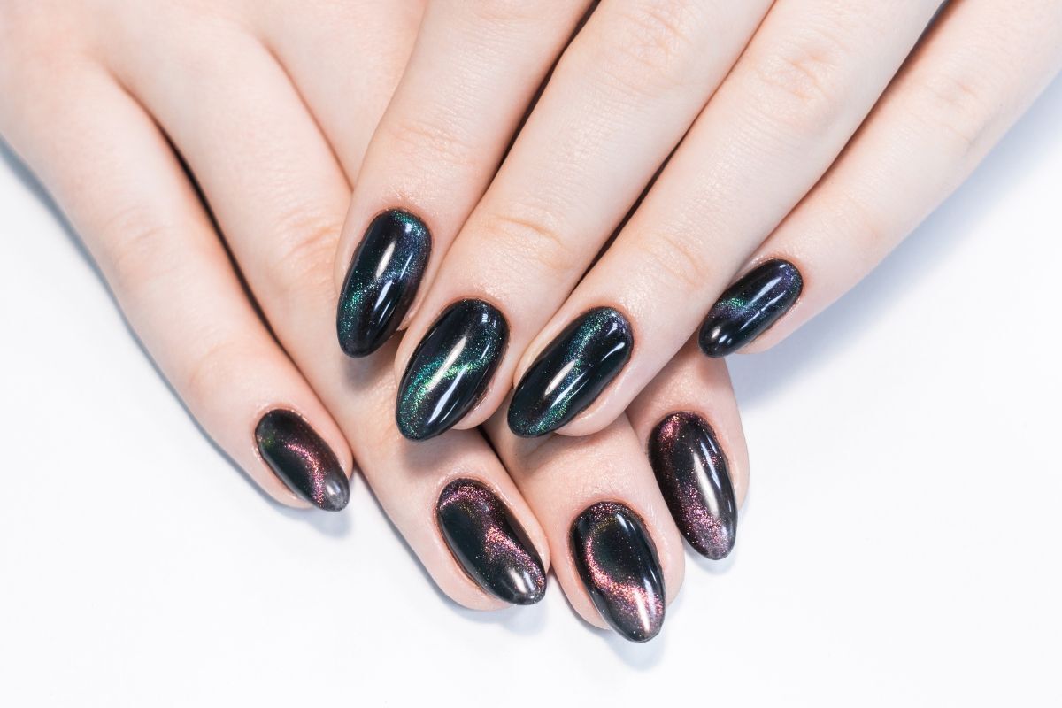 nail mắt mèo hai bàn tay màu xanh đen và màu đỏ tím chồng lên nhau trên nền trắng