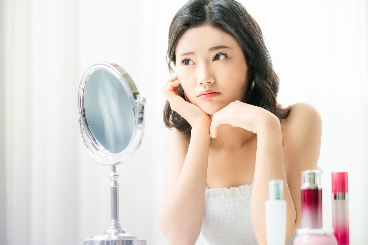 Cô gái ngồi chống tay vào cằm vẻ mặt suy nghĩ treatment là gì