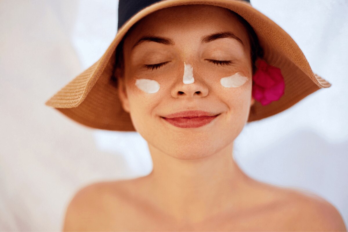 da bị kích ứng cách cải thiện làn da bị kích ứng chống nắng thật kỹ cô gái đội nón nhắm mắt với các vệt kem chống nắng trên hai má và đầu mũi