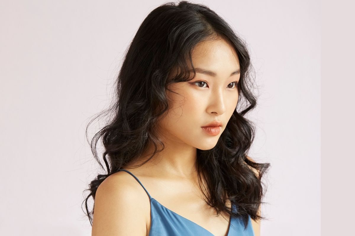 Mặt kim cương cô gái có mái tóc xoăn và mặc váy dây màu xanh dương 