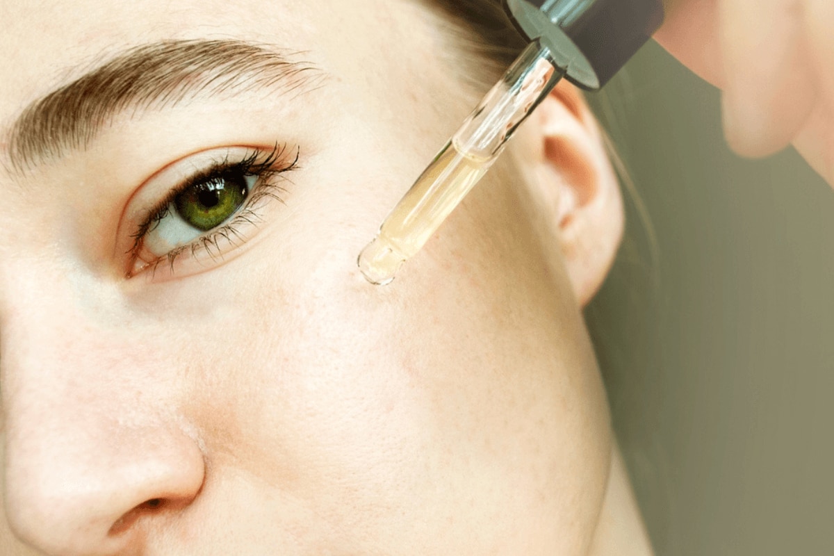 tác dụng của tinh dầu tràm trà tinh dầu tràm trà có tác dụng gì cô gái dùng ống serum đưa lên mặt