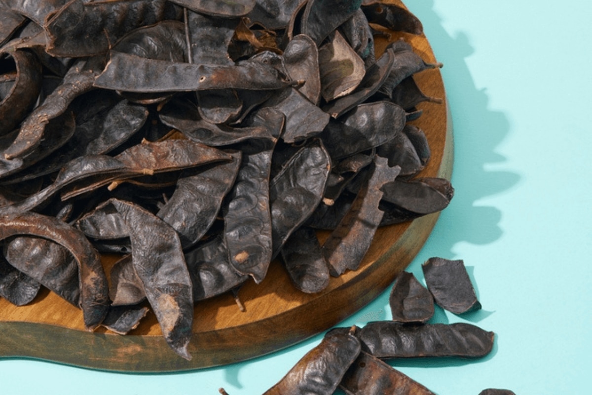 gội đầu dưỡng sinh chọn dầu gội phù hợp hình ảnh chụp bồ kết khô màu đen đặt trên khay gỗ