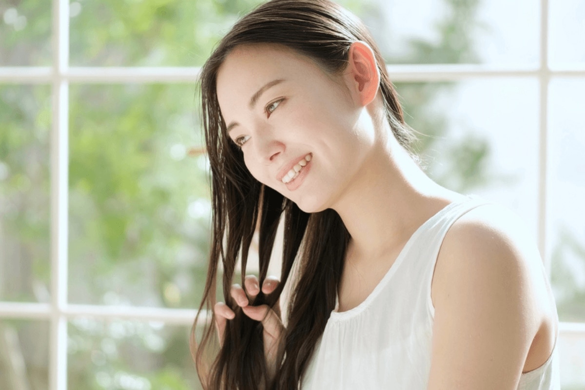 gội đầu dưỡng sinh dưỡng ẩm cho tóc khi gội đầu dưỡng sinh cô gái vuốt tóc bằng các ngón tay và mỉm cười