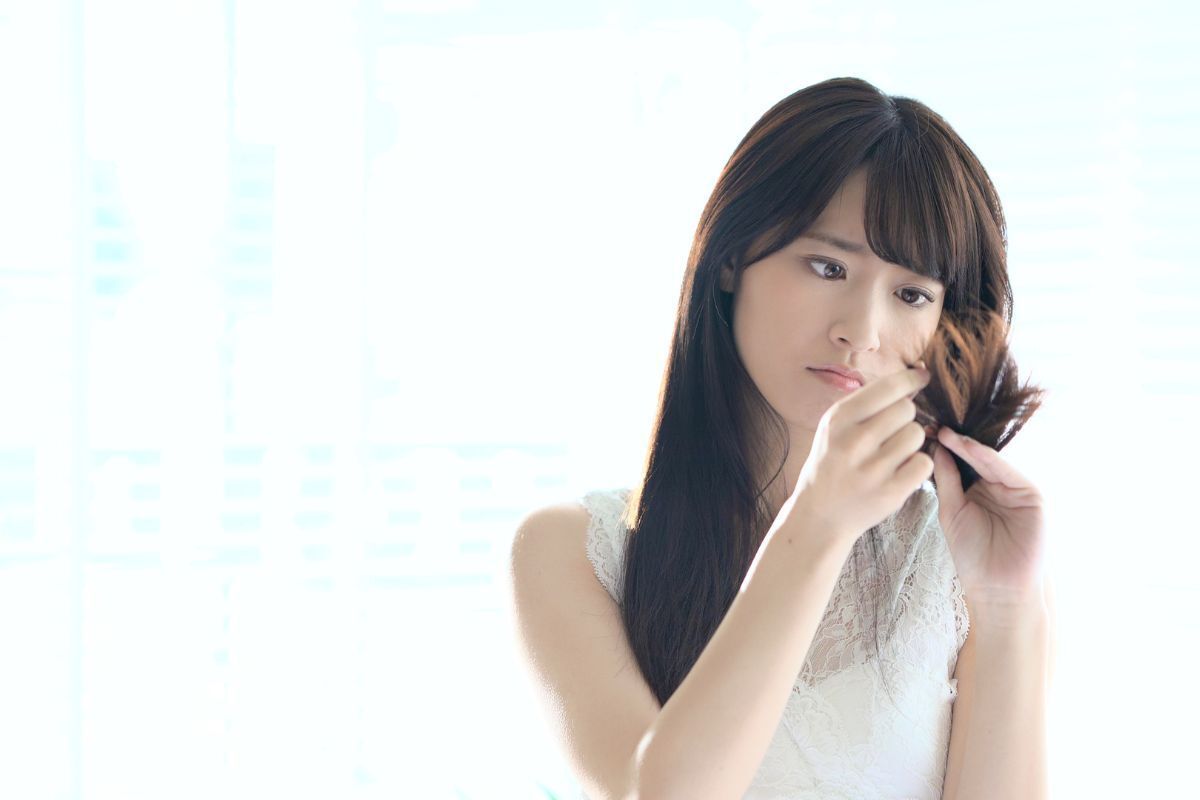 Cô gái đang quan sát phần đuôi tóc chẻ ngọn