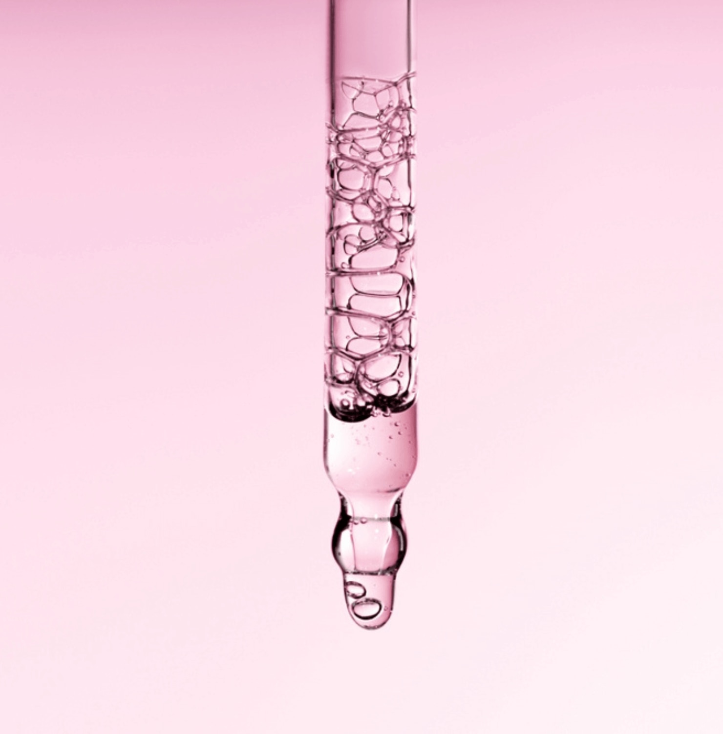 alpha arbutin kết hợp với niacinamide ống serum thẳng đứng với tinh chất trong suốt trên nền hồng ombre