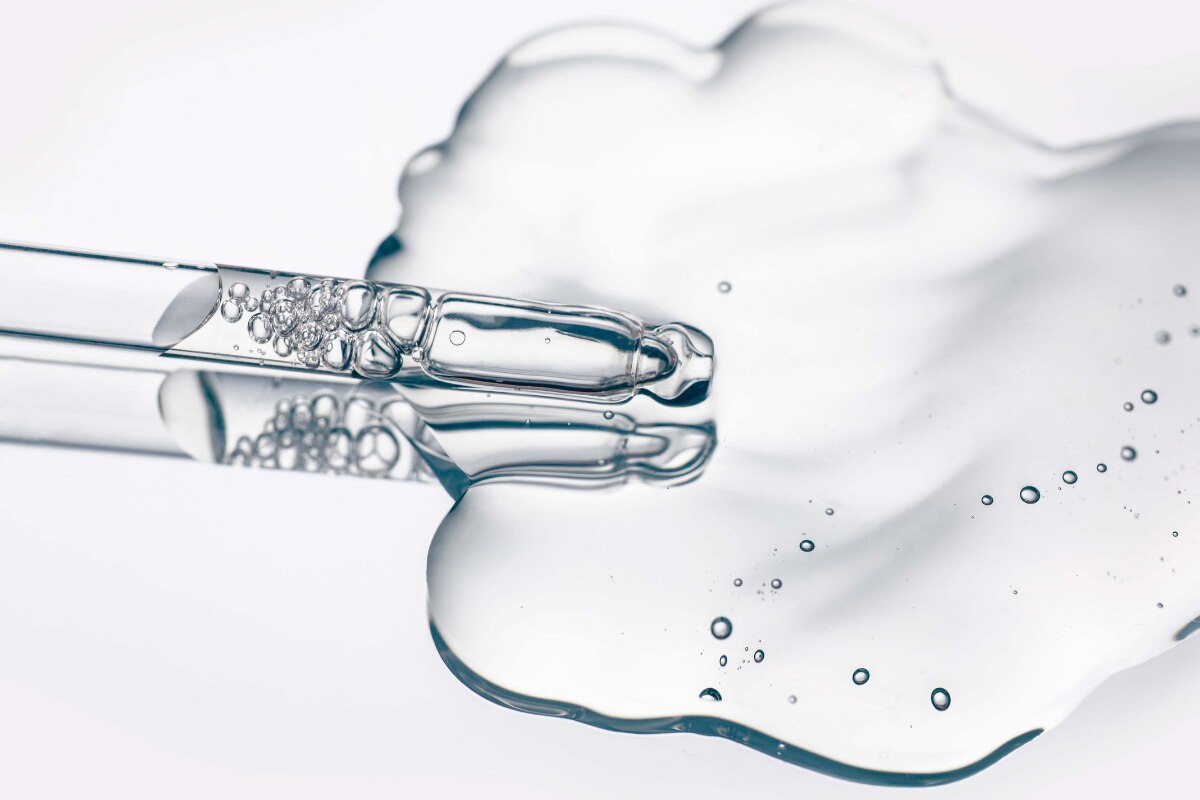 công dụng serum dưỡng tóc ống nhỏ serum dưỡng tóc màu trắng trên bàn.