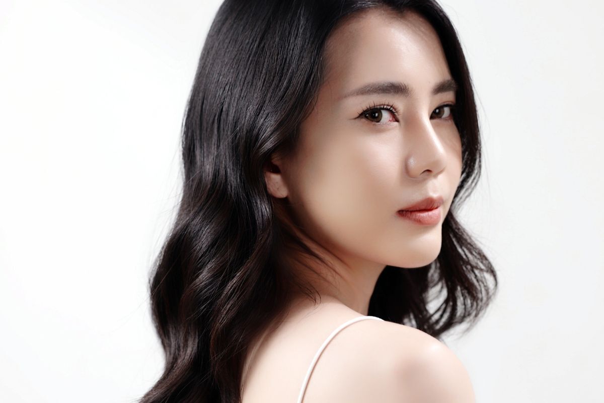 kiểu tóc cho người tóc mỏng đẹp cô gái tóc xoăn xoay mặt trên nền trắng