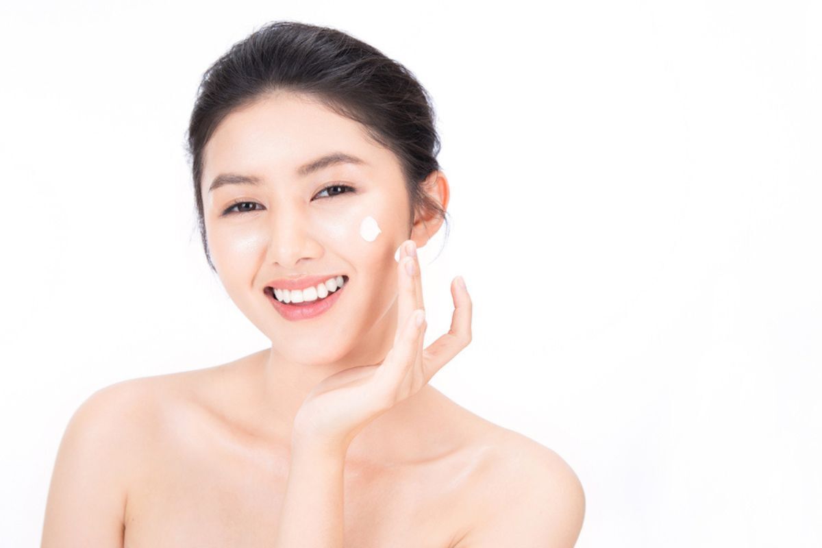 Bakuchiol lựa chọn sản phẩm phù hợp cô gái cười tươi đang thoa kem dưỡng
