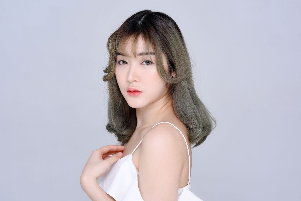 Tóc nhuộm màu rêu khói cô gái mặc váy hai dây đang quay người sang phía bên trái