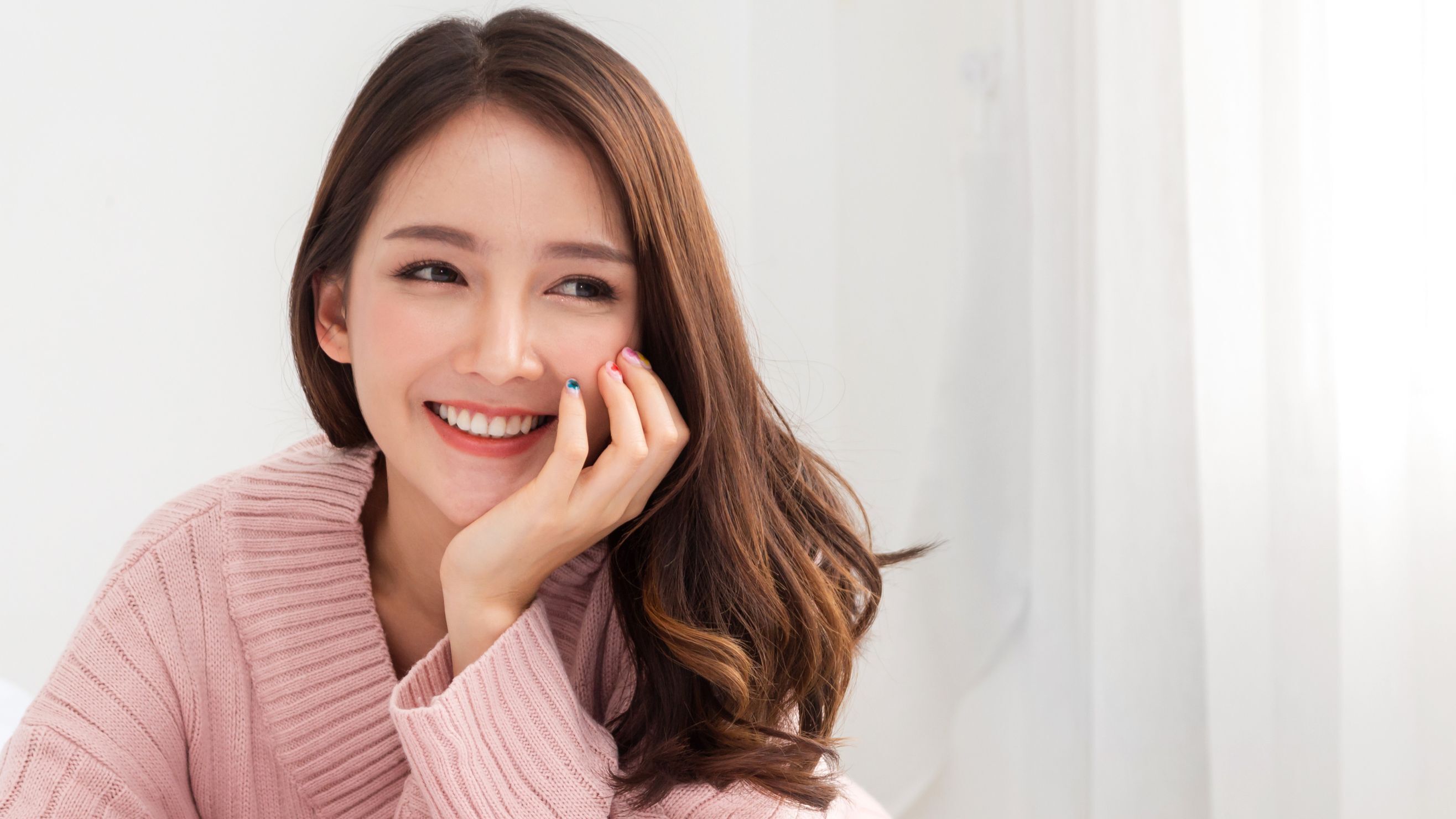 Cô gái cười tươi chống một tay vào cằm