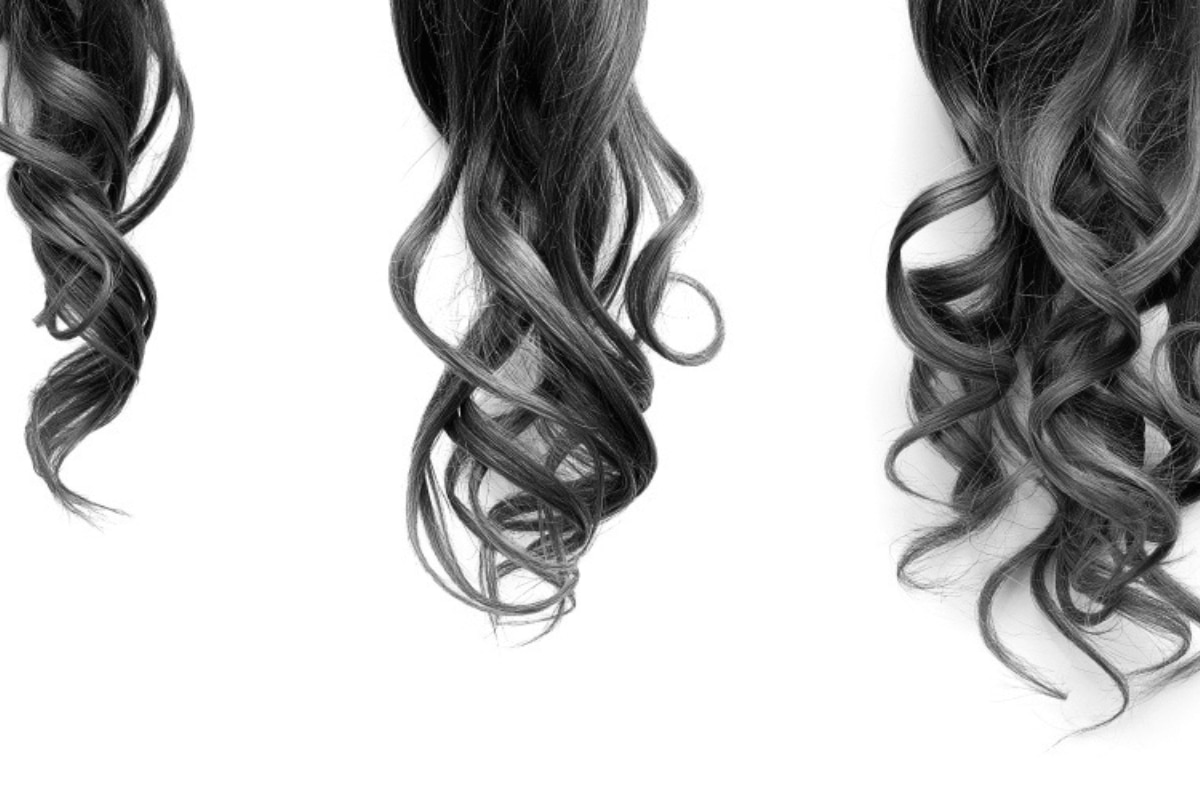 nguyên nhân rụng tóc ở nữ ba đuôi tóc xoăn có độ dài tăng dần trên nền trắng