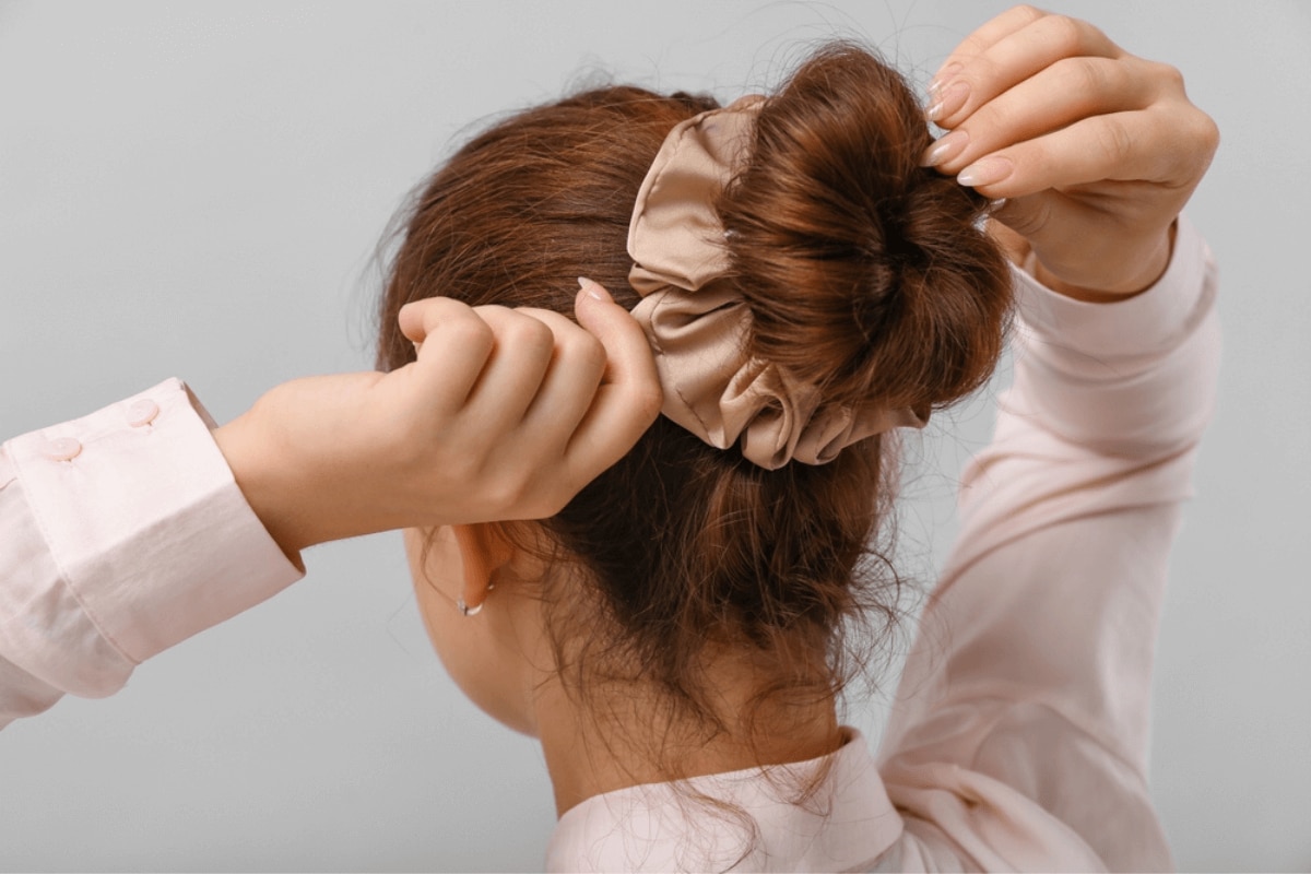 nguyên nhân rụng tóc ở nữ thói quen chăm sóc tóc chưa đúng cô gái đang búi tóc