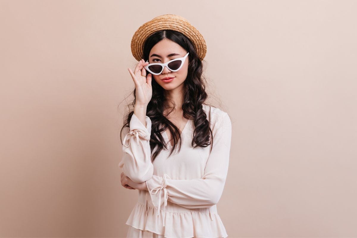 màu kem phối với màu gì cô gái đeo kính trắng và đội mũ cói mặc váy màu kem 