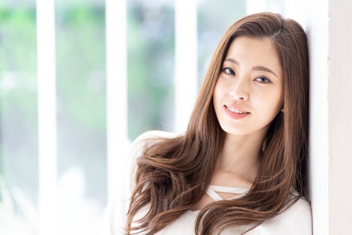 kiểu tóc màu nâu đẹp cô gái tóc dài uốn xoăn đuôi đầu dựa tường