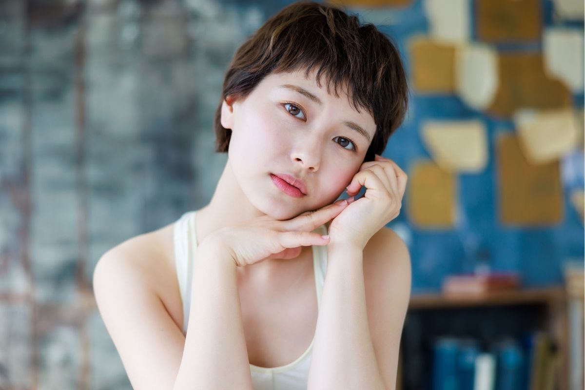 Kiểu tóc tém Nhật đẹp với mái bay mặc áo ba lỗ trắng chống hai tay vào má