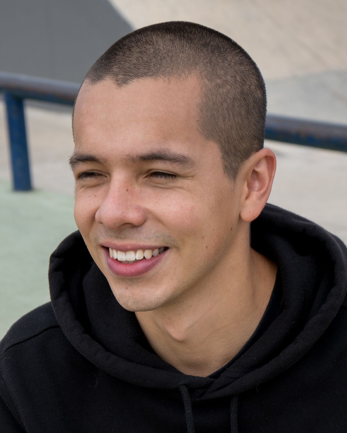 Tóc buzz cut tóc buzz cut là gì chàng trai mặc áo hoodie màu đen đang cười tươi