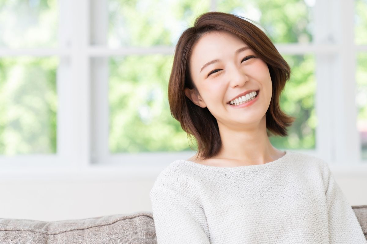 Kiểu tóc Wendy cô gái mặc áo trắng đang ngồi ghế sofa và cười tươi