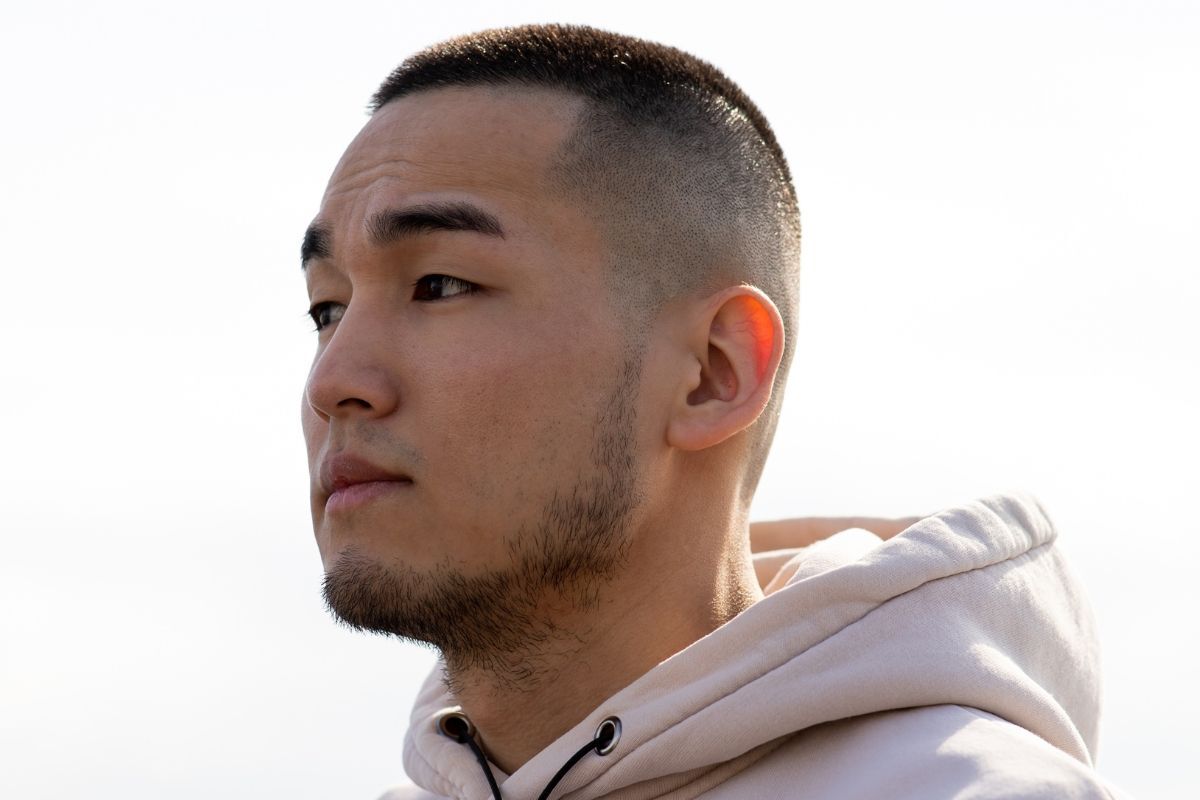 Tóc buzz cut kết hợp với mid fade chàng trai mặc áo có mũ đứng ngoài trời