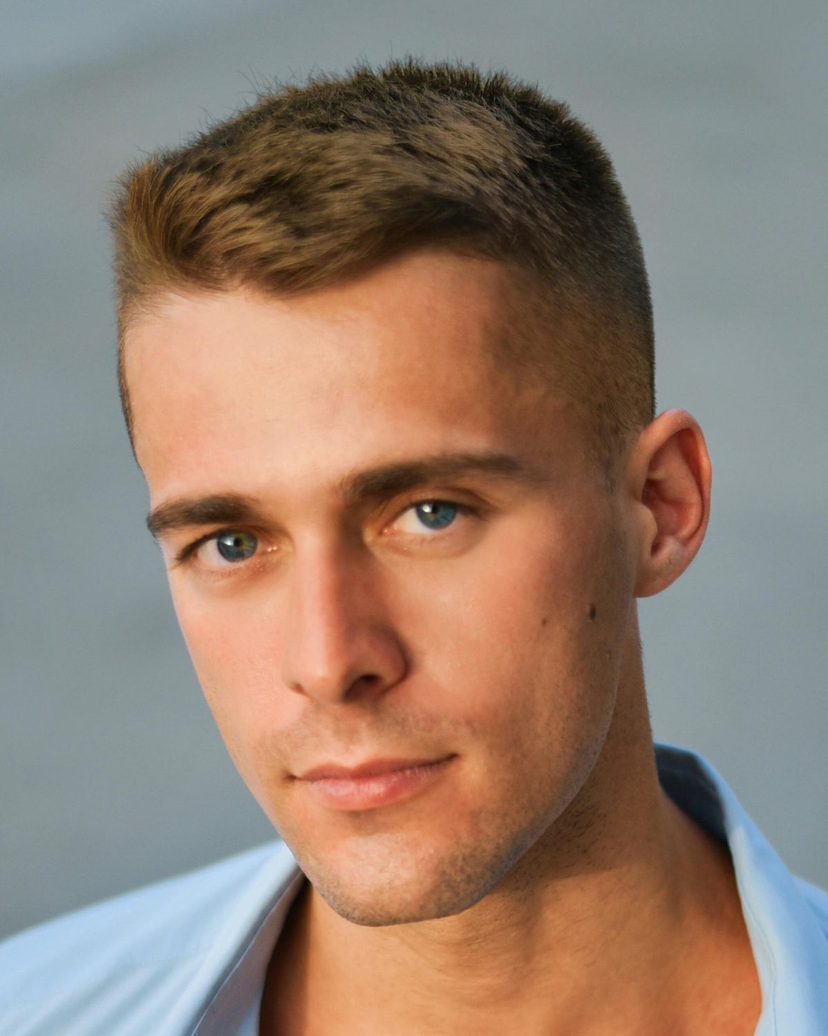 Tóc buzz cut kết hợp Side Swept ảnh chụp chính diện chàng trai mặc áo sơ mi xanh dương 