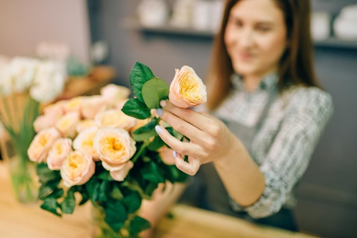 Các cắm hoa hồng người phụ nữ đang cầm cành hoa hồng màu vàng nhạt