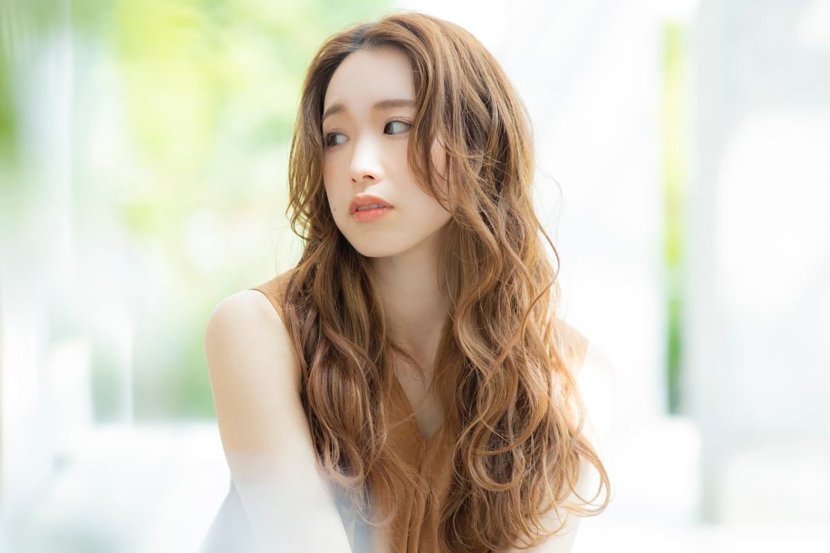 Cô gái có mái tóc màu nâu vàng dài và uốn xoăn 